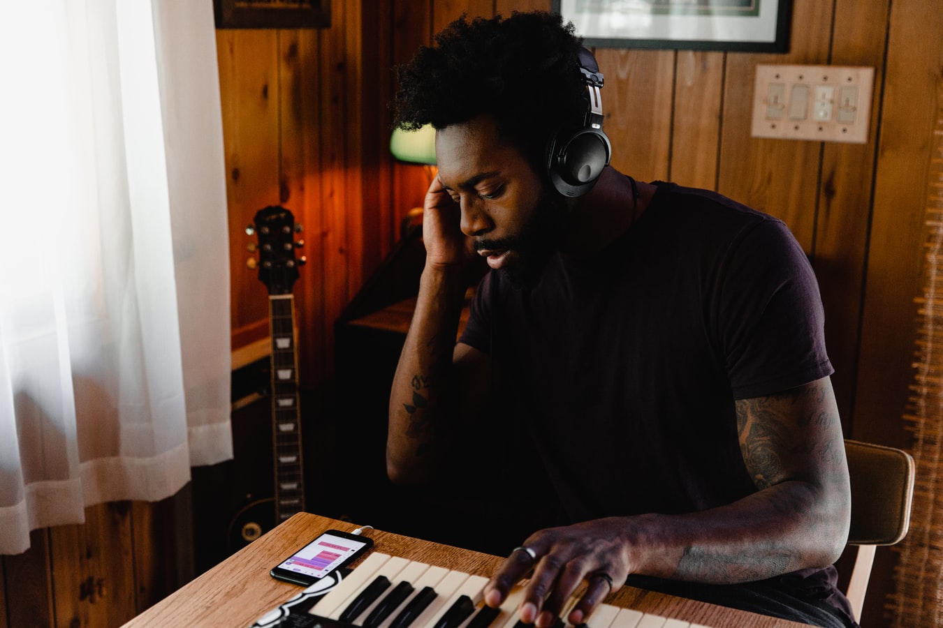 man listening to music at keyboard