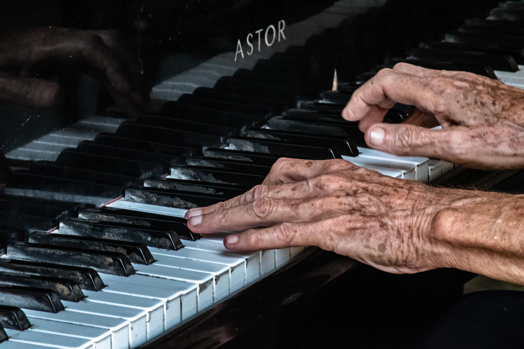 Elderly hands on old piano