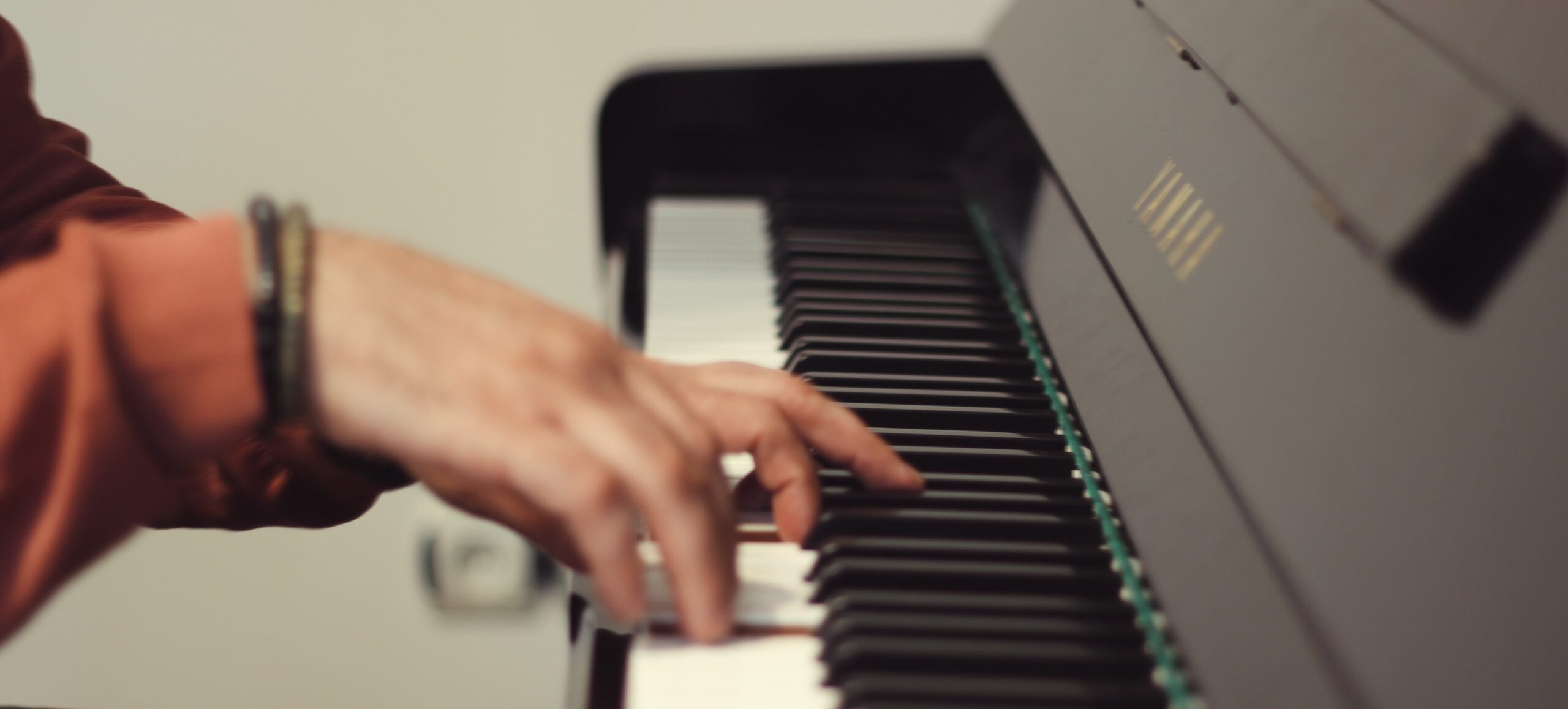 Hand on Yamaha piano keys