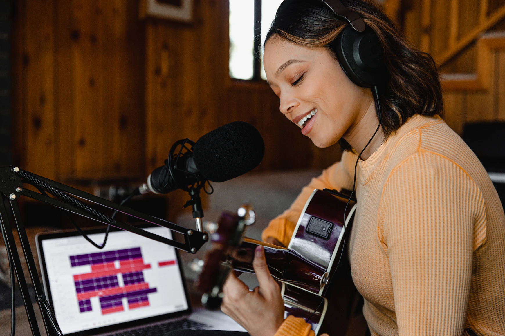 smiling lady with guitar at computer