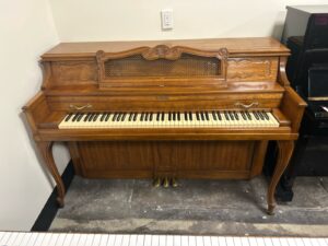 Used Baldwin vertical piano in French pecan finish