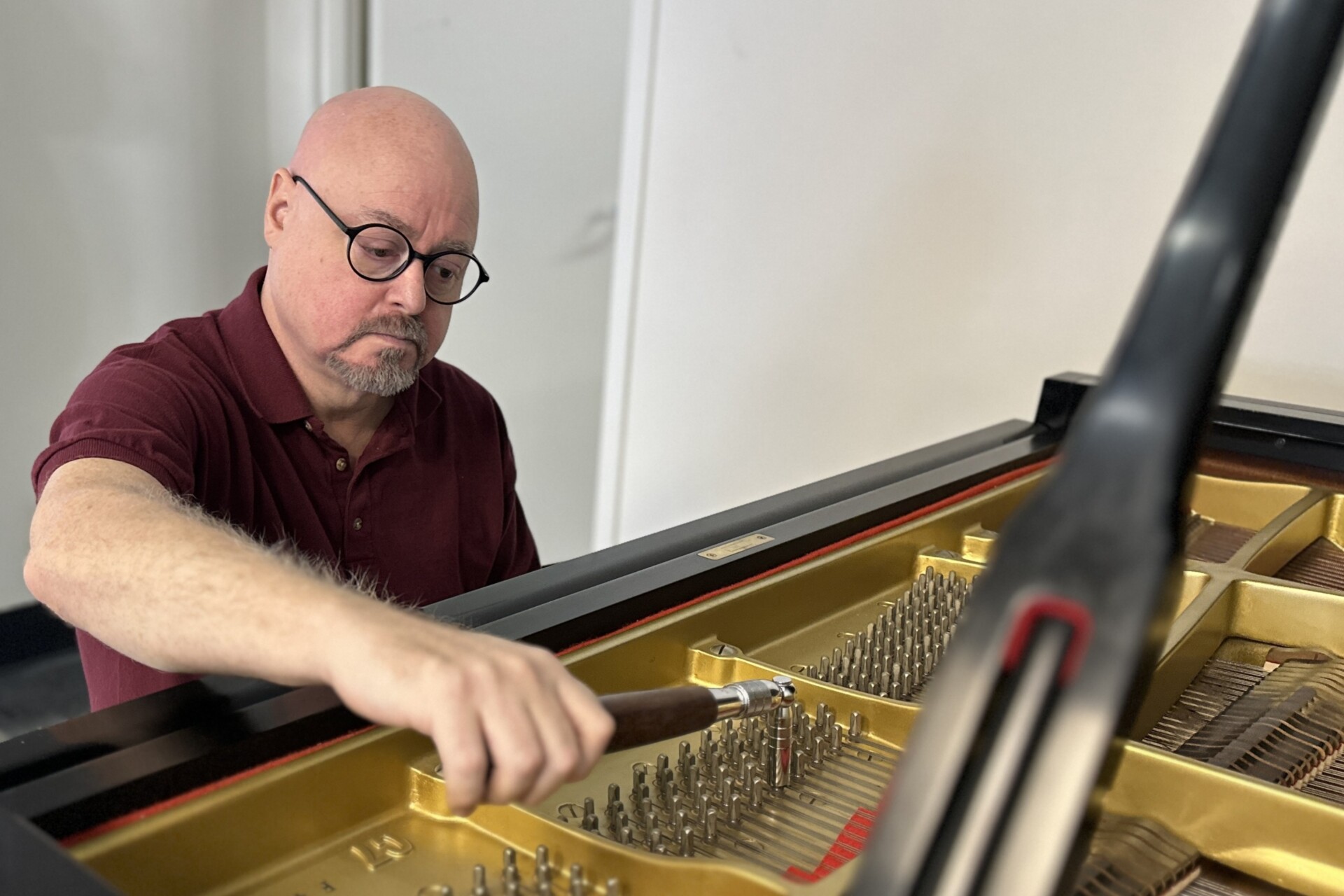 Joel Asher, a professional piano technician, tuning a grand piano