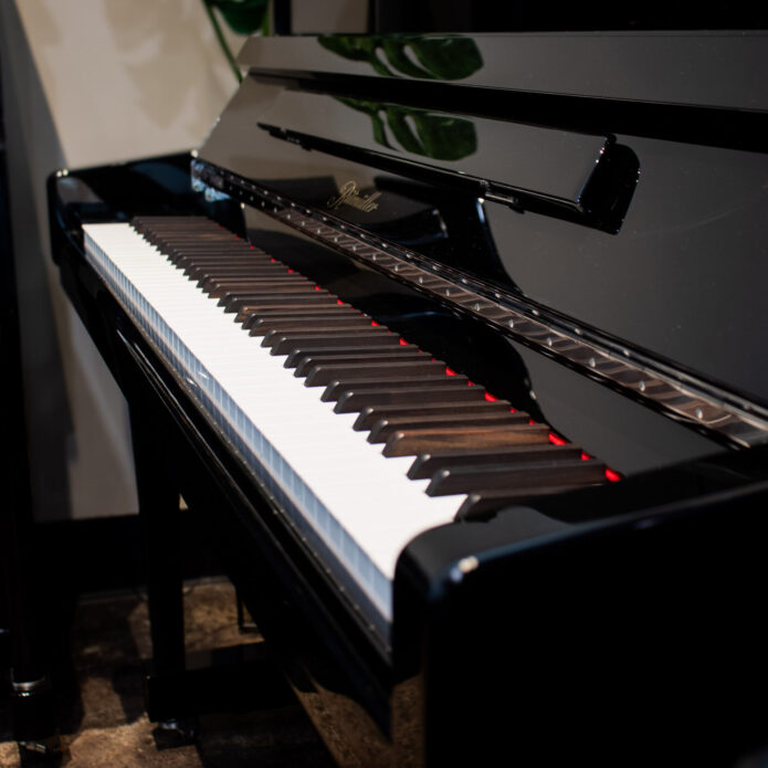 New Ritmüller UHX121 upright piano in polished ebony finish and genuine ebony sharps on display at Miller Piano Specialists showroom in Nashville, TN.