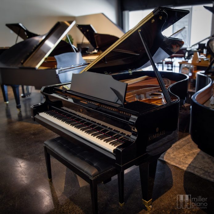 Kimball 670P Viennese Classic grand piano in polished ebony displayed in the Miller Piano Specialists showroom, with other grand pianos visible in the background.