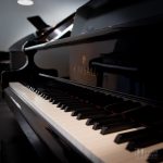 Close-up of the keyboard and side arm of the Kimball 670P Viennese Classic grand piano in the Miller Piano Specialists showroom.