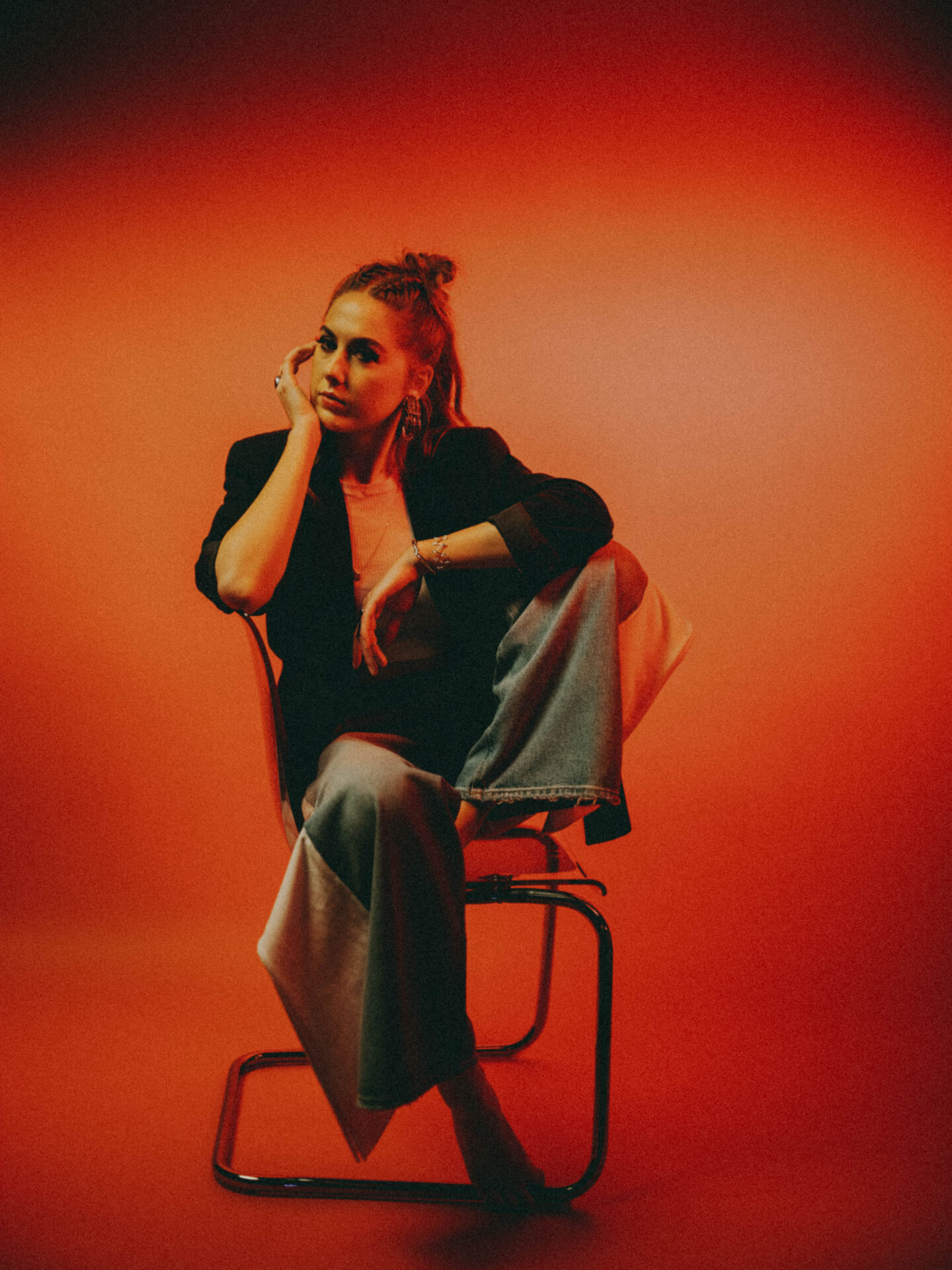 Sara Bares, Nashville-based singer-songwriter signed to Warner Chappell Music, seated in a studio portrait with warm lighting